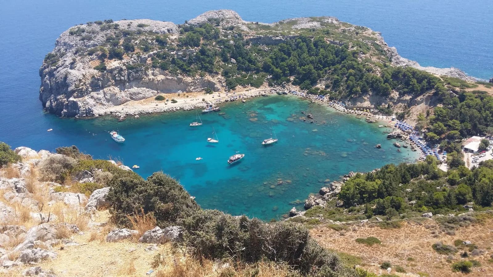 Anthony Quinn Bay south of Faliraki on the east coast of Rhodes, a turquoise cove enclosed by a rocky headland with boats at anchor