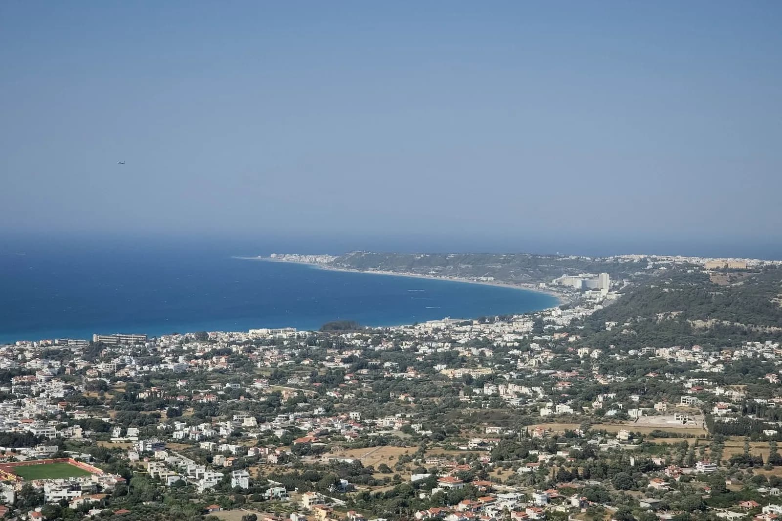 The bay of Ialyssos and Ixia on the north-west coast of Rhodes, seen from the hill of Filerimos, with hotels along the shore and Rhodes Town in the distance