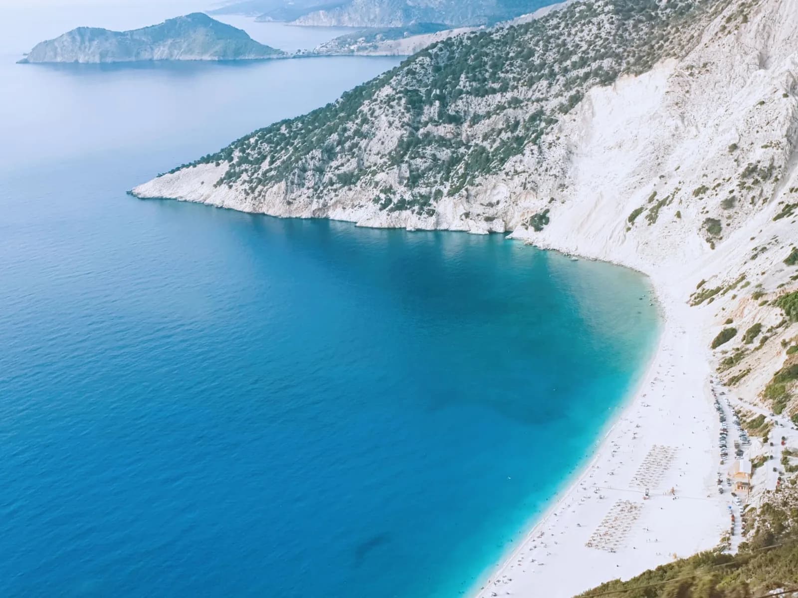 Myrtos beach and its white cliffs on the west coast of Kefalonia, with the Assos peninsula beyond
