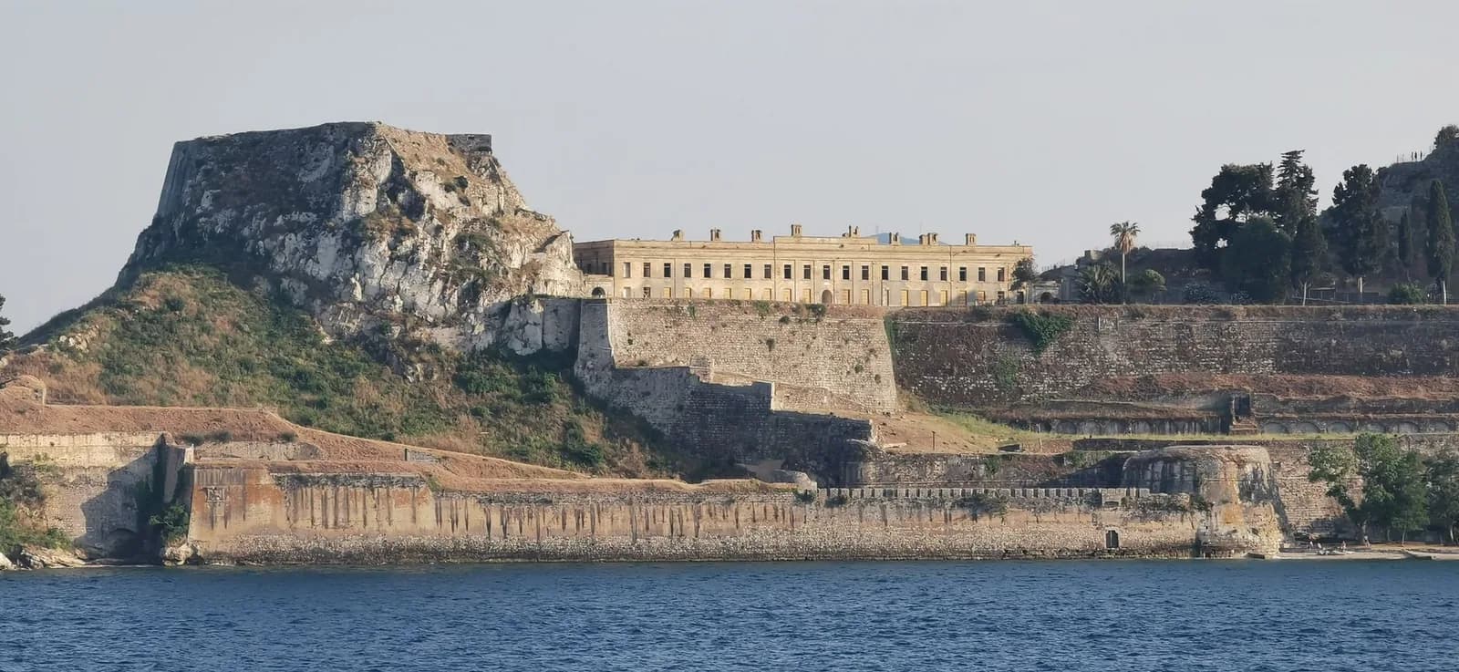 The Old Fortress of Corfu Town seen from the sea, with its rock peak, the British barracks building and the Venetian sea walls