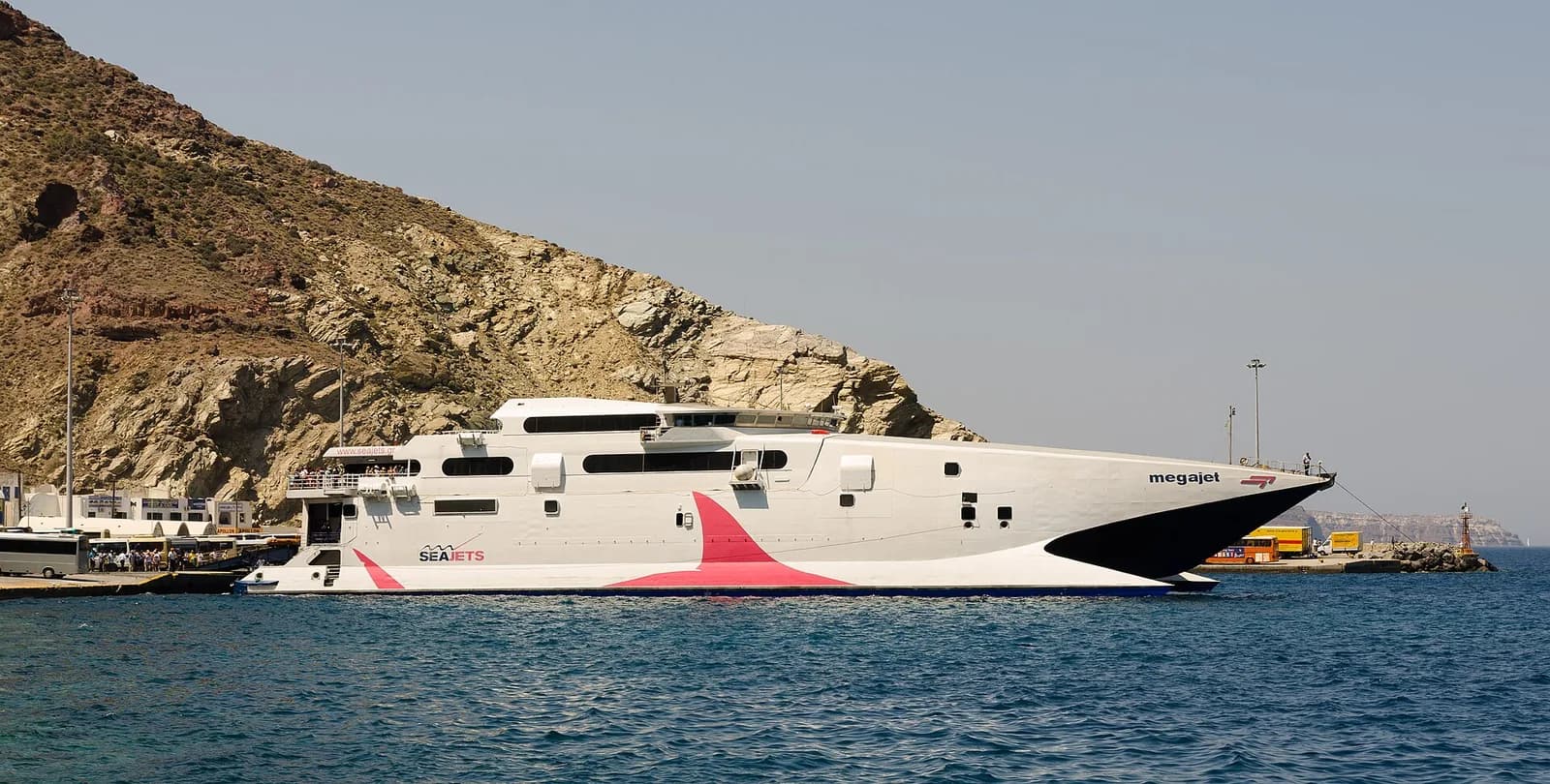 SeaJets Megajet catamaran docked at Athinios port, Santorini, below the caldera cliff