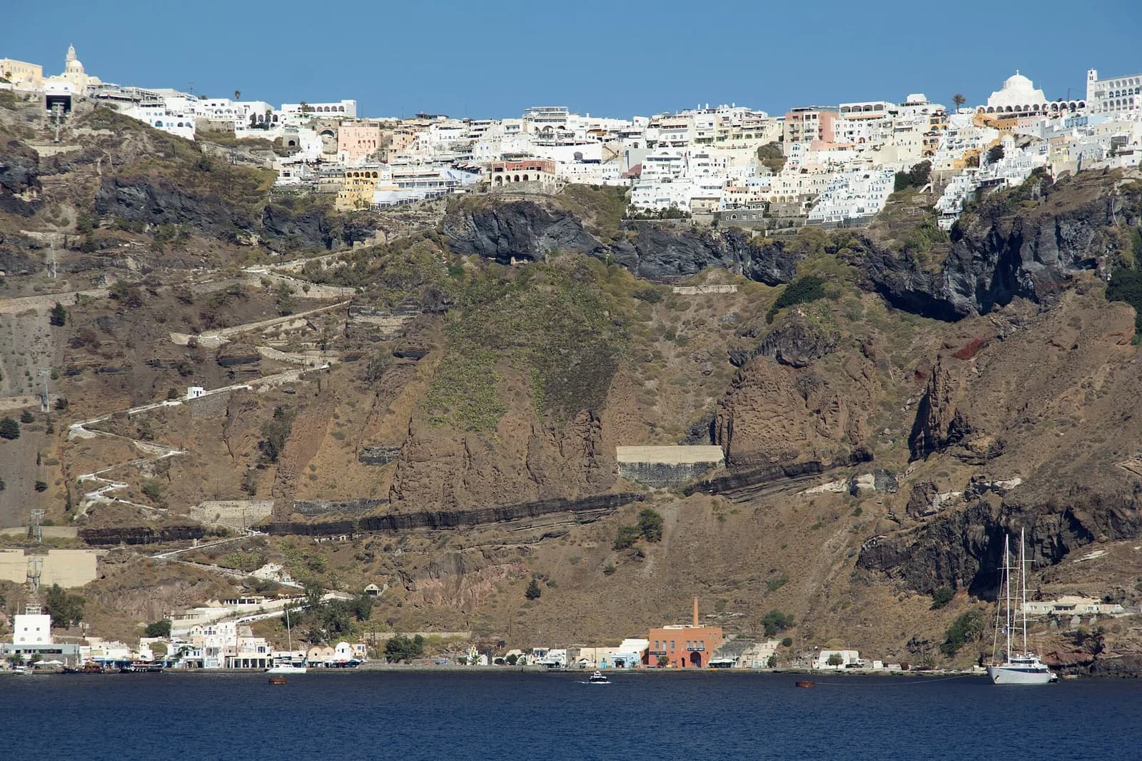 Old port of Fira (Skala Gialos) below the caldera cliff, with the zigzag donkey path up to Fira town, Santorini
