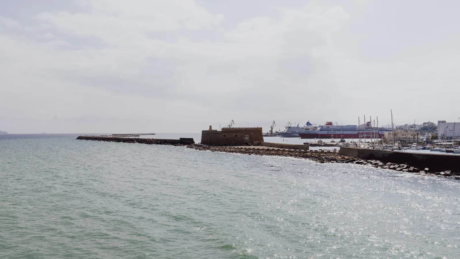 Ferries berthed at the commercial port of Heraklion in Crete, seen past the sea wall and the Venetian fortress