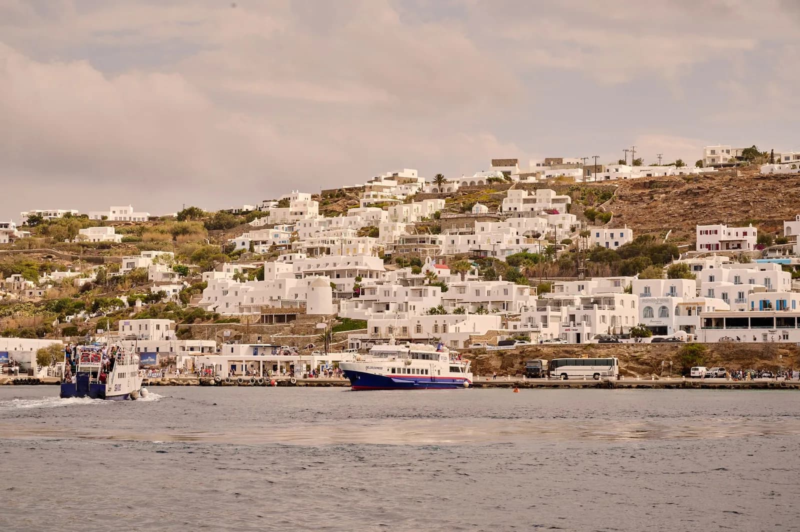 The old port of Mykonos with excursion boats and the whitewashed town rising behind the quay