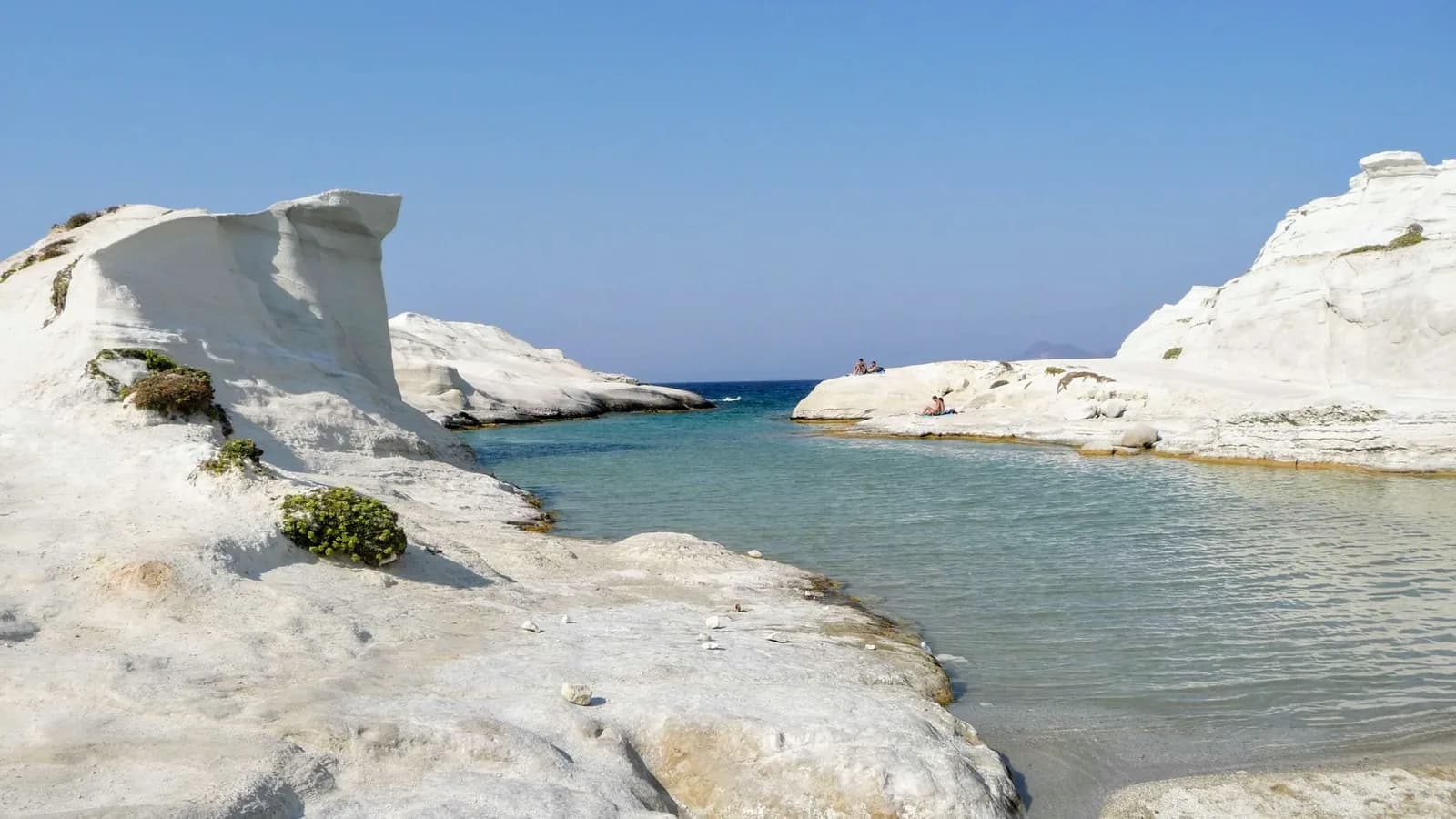 The white volcanic rock of Sarakiniko on Milos, worn smooth and cut by a turquoise inlet