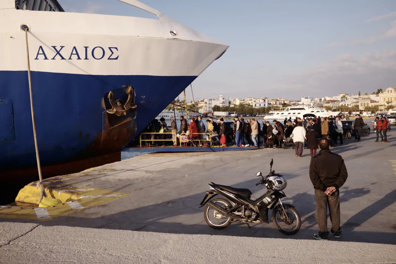 Saronic Ferries car ferry Achaios at the quay in Aegina port, with passengers boarding over the open ramp