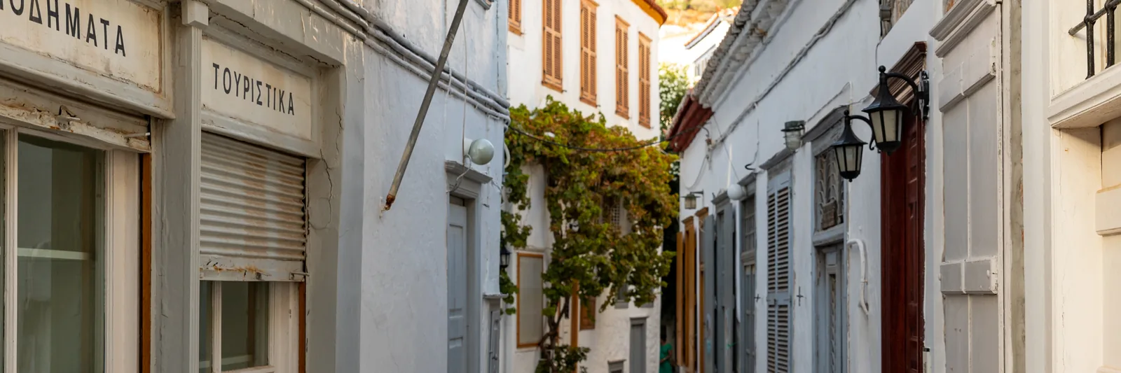 Narrow cobbled lane between whitewashed stone houses in Hydra town