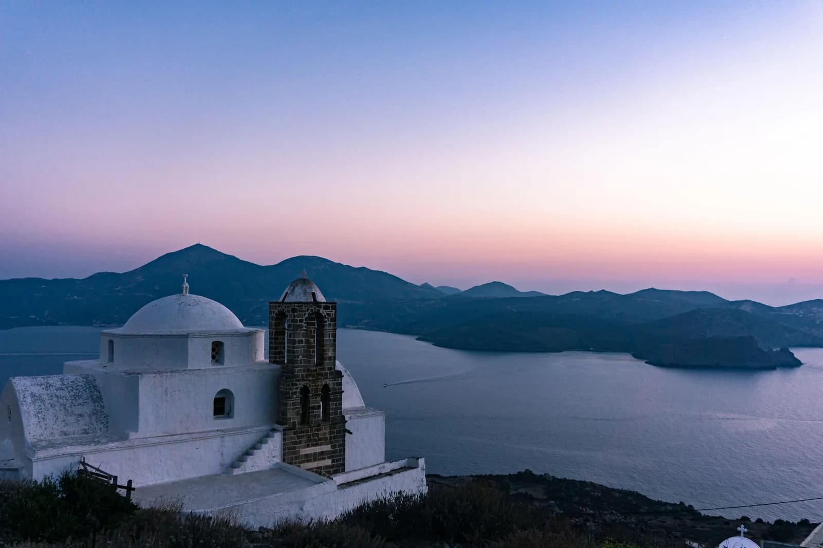 The church of Panagia Thalassitra above Plaka at dusk, looking down over the great volcanic bay of Milos