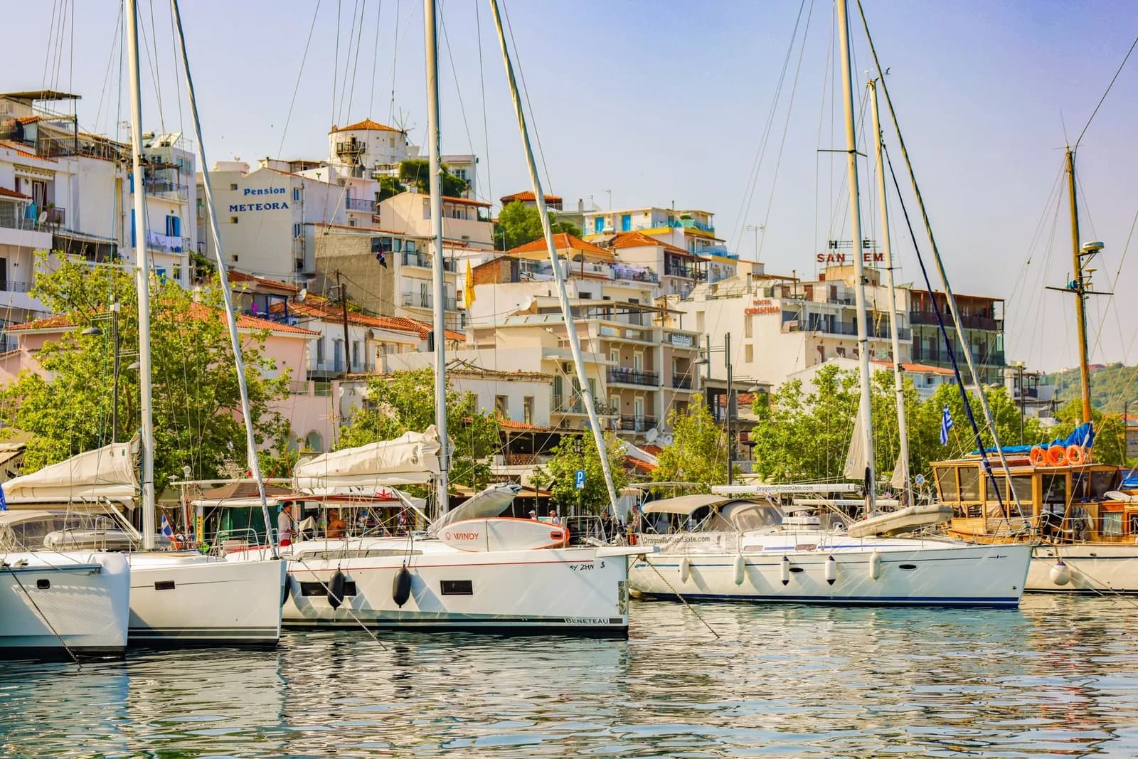 Hotels and pensions stacked above the yacht harbour in Skiathos Town, with the wooded hills of the island behind, Sporades, Greece