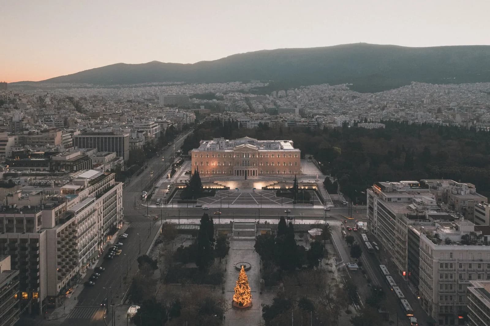Aerial view of the Greek Parliament and Syntagma Square in Athens at dusk, with the city spreading out beyond