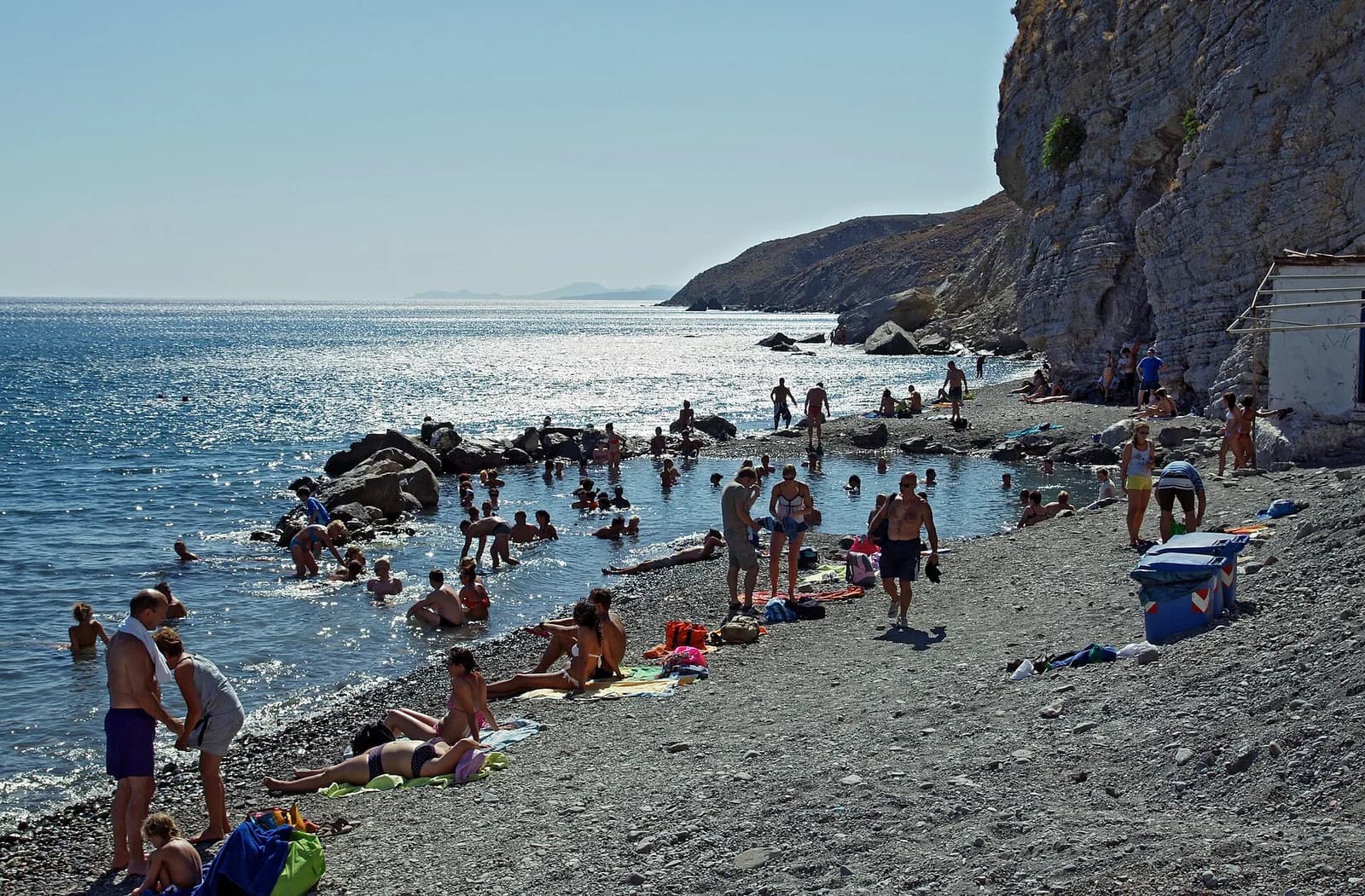 Bathers in the pool of volcanic hot water on the shingle beach at Therma, below the cliffs beyond Agios Fokas on Kos
