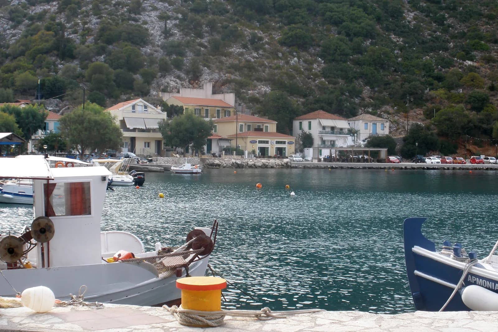 Fishing boats moored in the small harbour of Frikes in the north of Ithaca, Greece, with tavernas along the quay