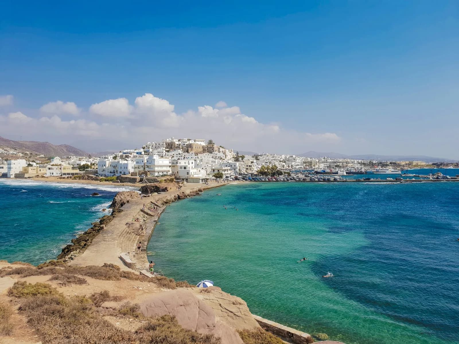 Naxos Chora seen from the Portara headland, with the causeway leading across to the town, the Venetian Kastro on the hill and the ferry port on the right